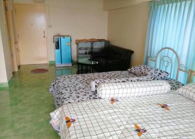 Spacious bedroom with double bed and green tiled flooring