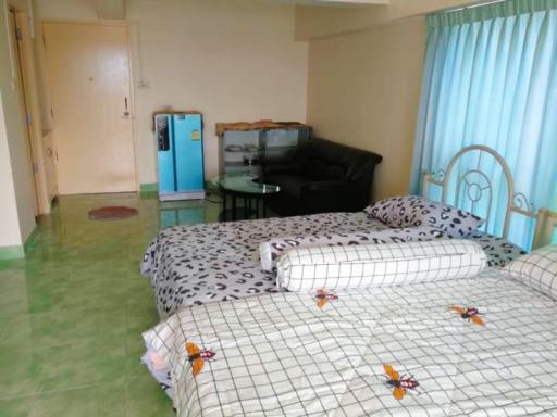 Spacious bedroom with double bed and green tiled flooring