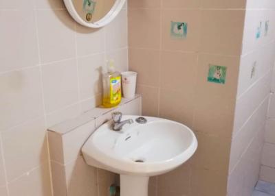 Compact bathroom with wall-mounted sink and mirror