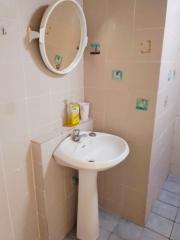 Compact bathroom with wall-mounted sink and mirror