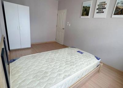 Compact bedroom with a large bed and wooden flooring