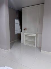 Spacious and minimalistic living room with white wall unit and large window