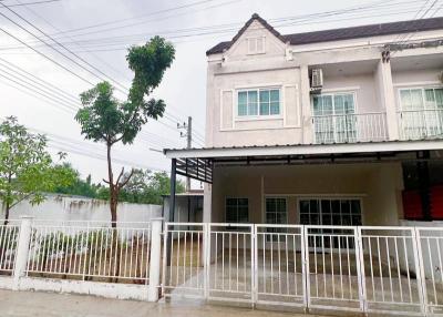 Two-story residential home with front gate and carport