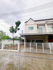 Two-story residential home with front gate and carport