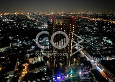 Aerial night view of a bustling cityscape with illuminated buildings