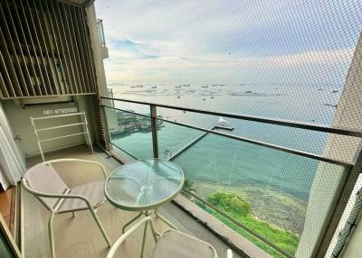 Ocean view balcony with seating area and safety railing