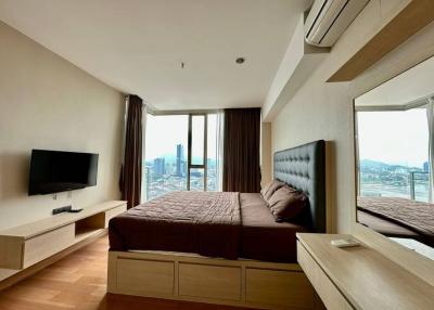 Modern bedroom with a view, queen-size bed, and wall-mounted television