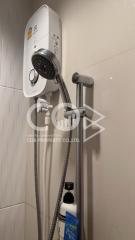 Modern wall-mounted electric shower unit with adjustable shower head in a tiled bathroom