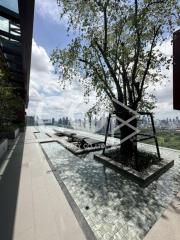 Spacious outdoor terrace with city skyline view and lush tree