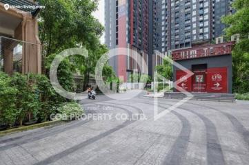 Exterior view of a modern apartment complex with designated pathway and lush landscaping