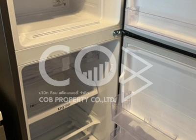 Open refrigerator in a kitchen showing empty shelves and drawers