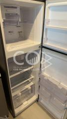 Open refrigerator in a kitchen showing empty shelves and drawers