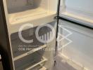 Open refrigerator in a kitchen showing empty shelves and drawers