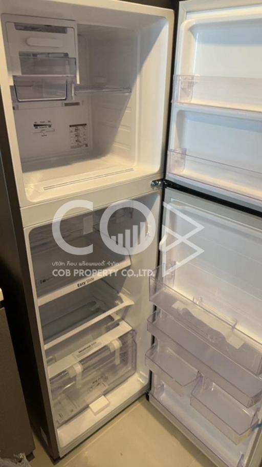 Open refrigerator in a kitchen showing empty shelves and drawers