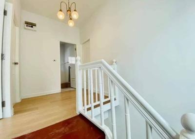 Bright hallway with wooden flooring and white balustrade