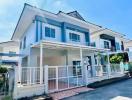 Two-story blue and white suburban house with a balcony and front porch