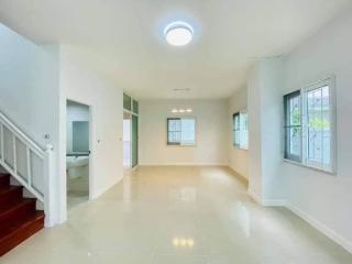 Spacious and well-lit living room with staircase and tile flooring