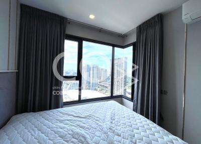 Modern bedroom with a city view and ample natural light