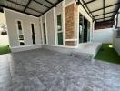 Spacious patio area with tiled flooring and artificial grass