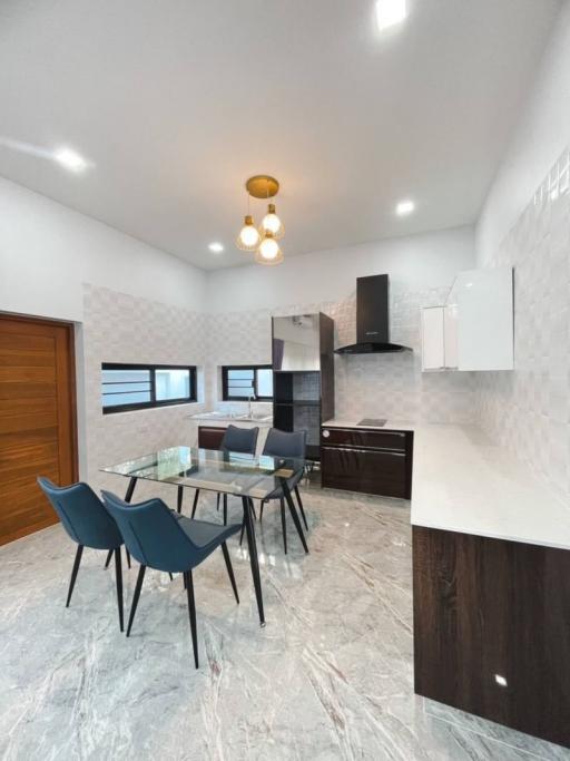 Sleek modern kitchen with dining area and marble flooring