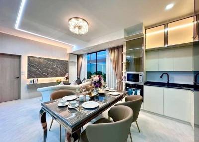 Modern dining room with open plan kitchen, elegant table set, and a view to the outside