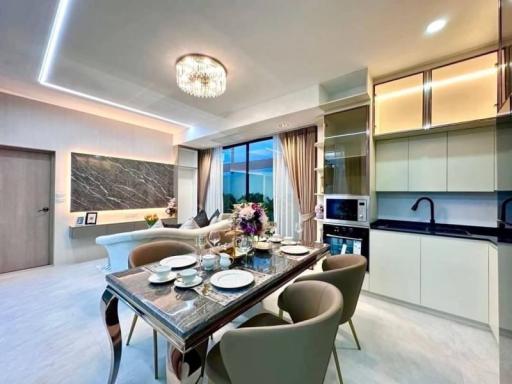 Modern dining room with open plan kitchen, elegant table set, and a view to the outside