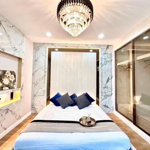 Elegant bedroom with marble wall design and modern chandelier