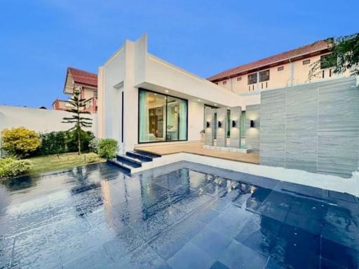 Modern house with exterior view showcasing the pool and patio area during twilight