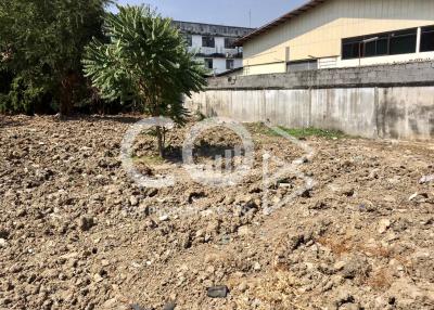 Vacant land with rough terrain and a surrounding wall