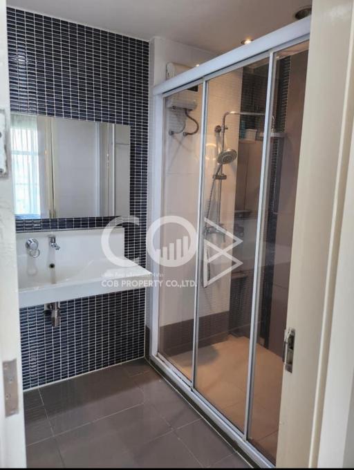 Modern bathroom with shower and blue tile wall
