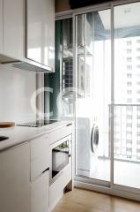 Modern kitchen with built-in appliances and a dedicated laundry area