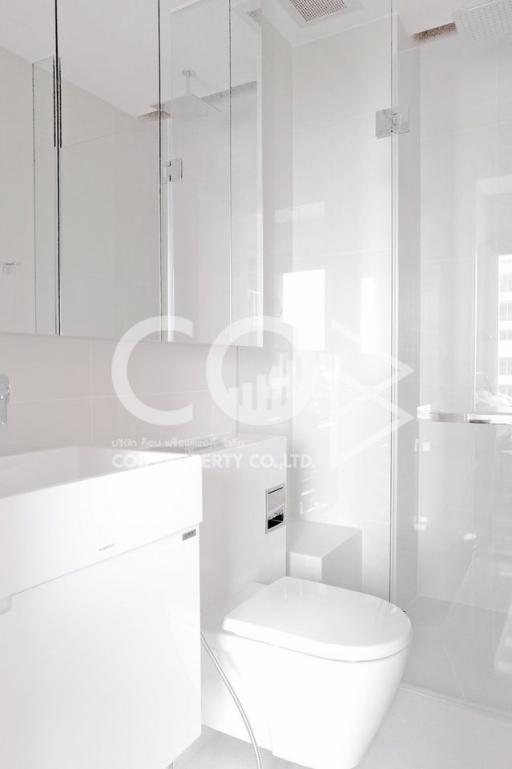 Modern bathroom with white fixtures and glass shower partition