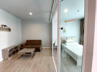 Modern living room with an adjacent bedroom visible through a glass partition