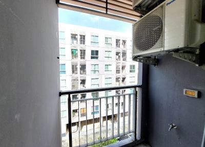 Compact balcony with air conditioning unit and urban view