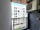 Compact balcony with air conditioning unit and urban view