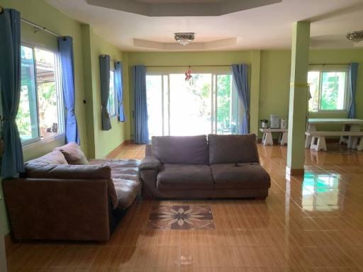 Spacious living room with large windows and tiled flooring