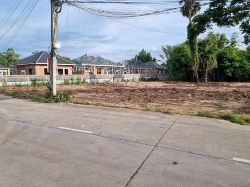 Suburban street view showing a residential property under construction with clear skies