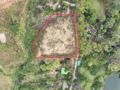 Aerial view of the vacant land with property boundaries marked, adjacent to natural surroundings and a water body