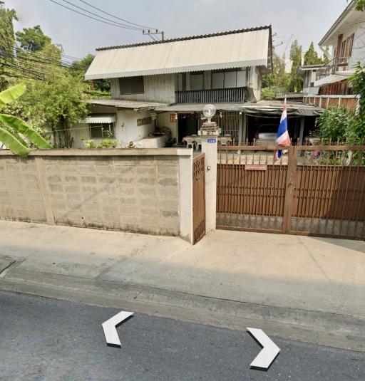 Suburban house with a gray fence and gated entry