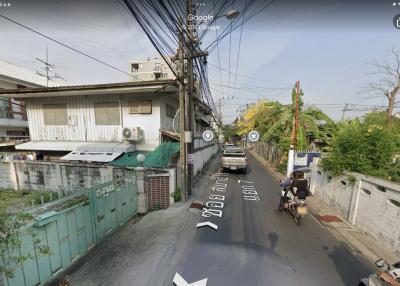 Street view of a residential area with houses, wiring, and a motorcycle