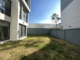 Modern residential building exterior with a small garden area