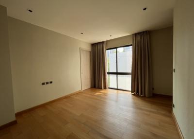 Spacious bedroom with hardwood floors and ample natural lighting