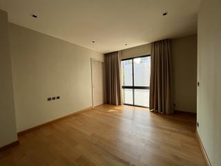 Spacious bedroom with hardwood floors and ample natural lighting