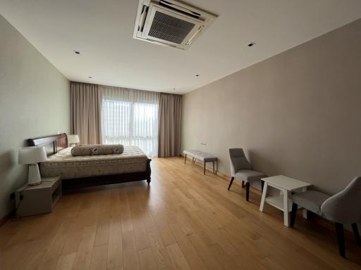 Spacious modern bedroom with large window and hardwood floors