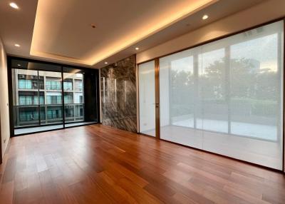 Spacious and well-lit living room with large windows and wooden flooring