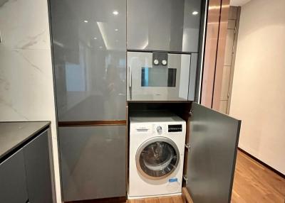 Modern laundry room with washing machine and built-in cabinets