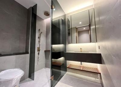 Modern bathroom interior with marble tiles and glass shower partition