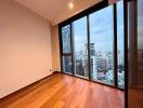 Spacious bedroom with large windows and city skyline view