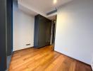 Empty bedroom with hardwood floors and white walls