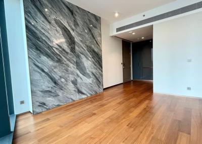 Empty interior space of a building with hardwood floors and a large accent marble wall